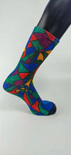 Load image into Gallery viewer, A bamboo sock with a cubist caricature of a face in teal, red, green, blue, and yellow geometric shapes