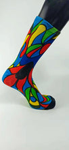 Load image into Gallery viewer, A stylistic bamboo sock with flowing whimsical designs in yellow, purple, blue, black, and red shapes.