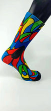 Load image into Gallery viewer, A stylistic bamboo sock with flowing whimsical designs in yellow, purple, blue, black, and red shapes.