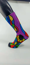 Load image into Gallery viewer, A stylistic bamboo sock with flowing whimsical designs in yellow, purple, blue, black, and red shapes.