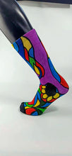 Load image into Gallery viewer, A stylistic bamboo sock with flowing whimsical designs in yellow, purple, blue, black, and red shapes.