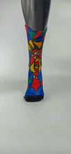 Load image into Gallery viewer, A bamboo sock with a cubist caricature of a face in teal, red, green, blue, and yellow geometric shapes.
