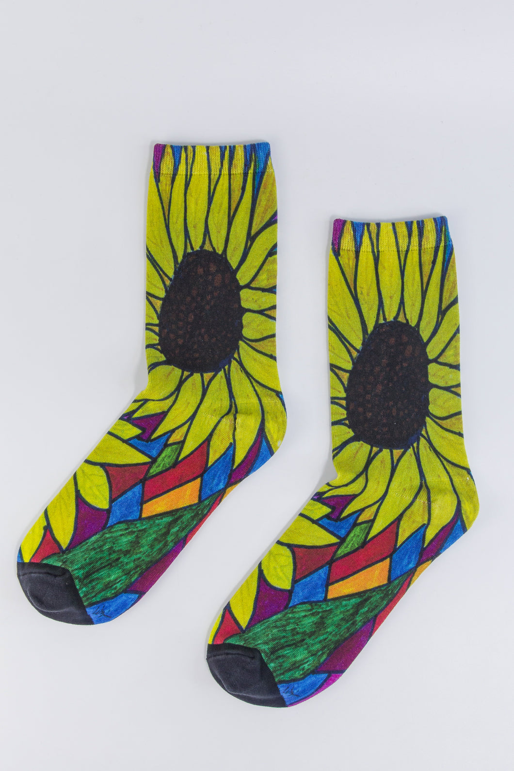 Bamboo sock with a large yellow sunflower design from the heel to the top of the sock outlined in green, blue, orange, and burgundy.