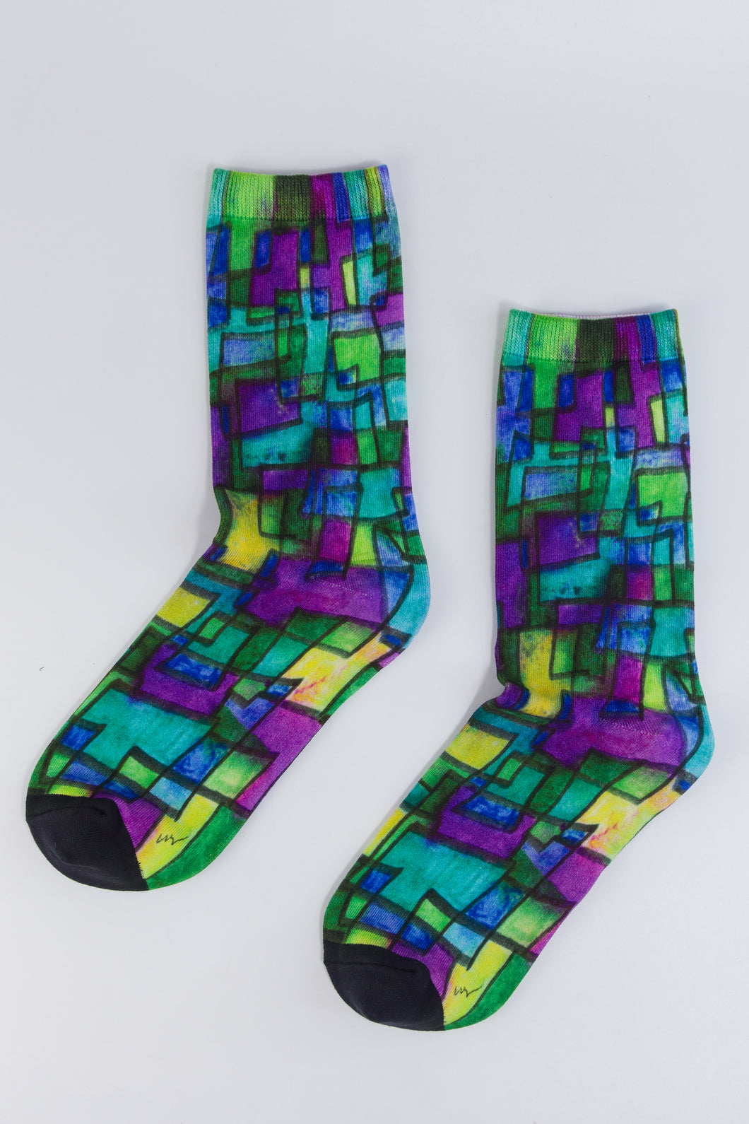 Abstract bamboo sock in purple, blue, yellow, and green geometrical designs. 
