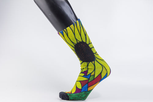 Bamboo sock with a large yellow sunflower design from the heel to the top of the sock outlined in green, blue, and burgundy.