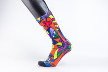 Load image into Gallery viewer, Bamboo sock with a stylistic face of a woman in green, red, blue, yellow, and orange.
